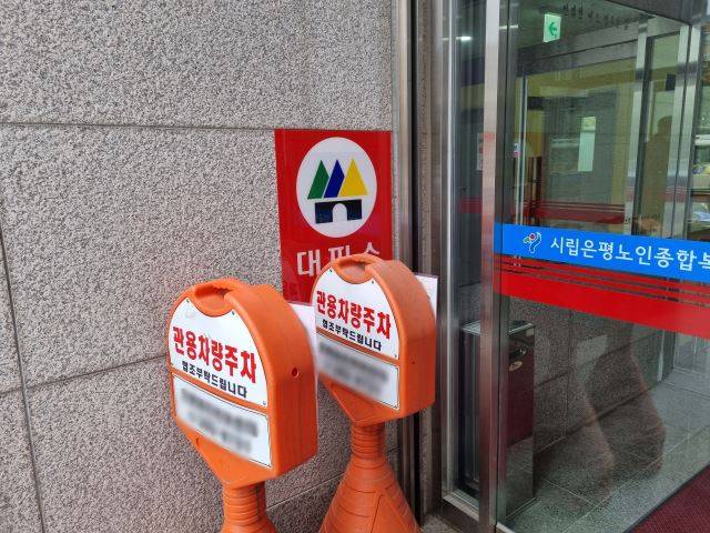 지난달 24일 서울 은평구 진관동의 서울시립은평노인종합복지관 벽면에 붙어있는 대피소 표지판이 이동식 주차 팻말에 가려져 있다. 이동환 기자