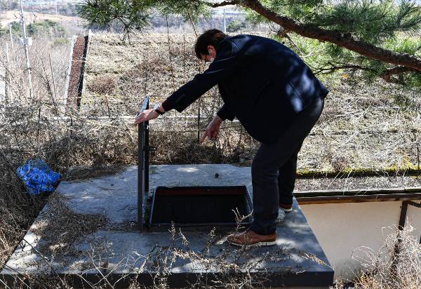 이태구 교수가 지난달 28일 충북 제천 의림지 인근 야산에 본인이 설치한 모형 방공호의 비상 탈출용 강철판에 대해 설명하고 있다. 제천=이한결 기자