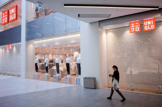 지난 11일 한 여성이 모스크바의 문을 닫은 유니클로 매장 앞을 지나가고 있다. H&M, 자라(Zara), 맥도날드, 이케아 등도 러시아 영업을 중단했다. AFP=연합뉴스