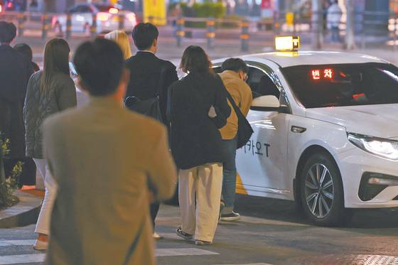 코로나19 방역을 위한 사회적 거리두기가 전면 해제된 지난 18일 서울 강남역 인근에서는 자정을 앞둔 늦은 시간에도 시민들이 빈 택시를 잡기 위해 모여들고 있다. 오랜만에 외부 활동을 즐기는 경우가 늘면서 ‘택시 대란’이 벌어지고 있다. [연합뉴스]