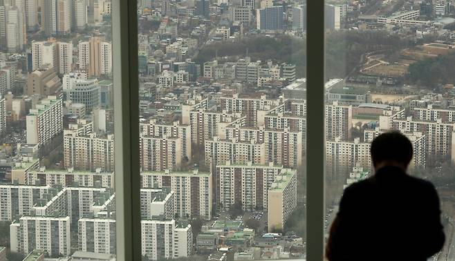 시민들이 서울 송파구 롯데월드타워 전망대에서 시내 아파트 밀집 지역을 바라보고 있다. / 연합뉴스