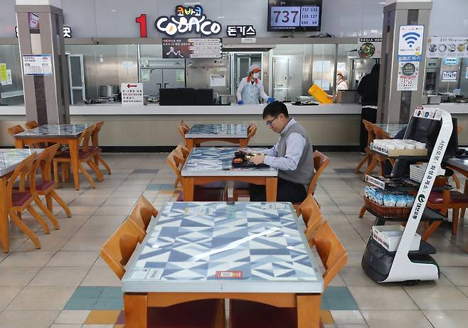 고속도로 한 휴게소 먹거리 장터에서 서빙 로봇이 밑반찬과 일회용품을 가져다주고 있다. 이 로봇은 정해진 동선을 따라 이동하다가 손님이 호출 버튼을 누르면 바로 찾아간다. / 장련성 기자