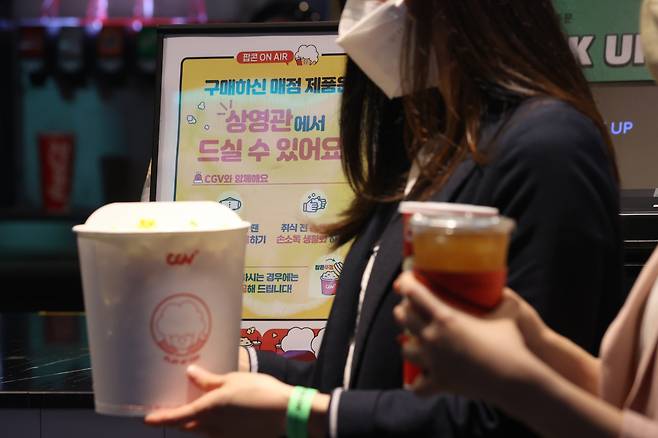 영화관 내 취식 금지가 해제된 25일 서울 용산구 CGV용산아이파크몰에서 관객이 팝콘 등을 들고 있다. [연합]