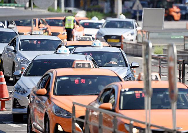 26일 오전 서울 중구 서울역 택시 승강장에서 택시들이 승객을 태우기 위해 줄지어 대기하고 있다. 서울시는 야간에 ‘택시 대란’이 발생하자, 0시부터 오전 4시까지인 심야 할증 시간대를 오후 10시에서 오전 4시로 연장해 심야 택시 운행을 늘리는 방안을 검토하고 있다.  윤성호 기자