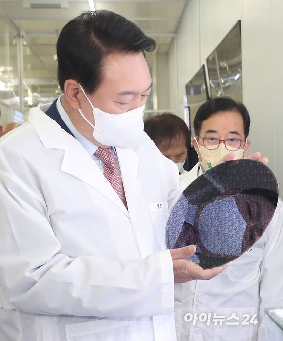 윤석열 대통령 당선인이 29일 오전 대전 한국과학기술원(KAIST) 내 나노종합기술원을 방문해 반도체 연구 현장을 둘러보던 중 반도체 웨이퍼 샘플을 들어보고 있다. [사진=인수위 사진기자단]