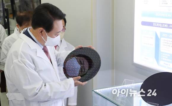 윤석열 대통령 당선인이 29일 오전 대전 한국과학기술원(KAIST) 내 나노종합기술원을 방문해 반도체 연구 현장을 둘러보던 중 반도체 웨이퍼 샘플을 들어보고 있다. [사진=인수위 사진기자단]
