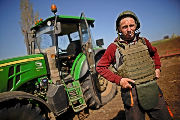 26일(현지시간) 돈바스와 인접한 우크라이나 남동부 자포리자에서 농부 유리이(41)가 방탄모와 방탄조끼를 챙겨 입고 들판에 서 있다./로이터 연합뉴스