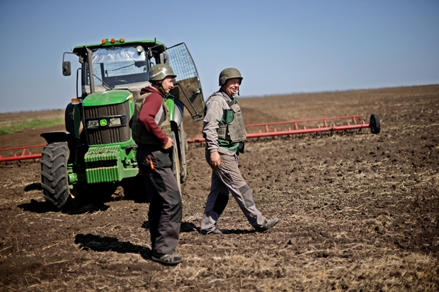 26일(현지시간) 우크라이나 남동부 자포리자에서 농부 유리이와 올레크시이가 방탄조끼와 방탄모를 착용하고 들판에 서 있다./로이터 연합뉴스