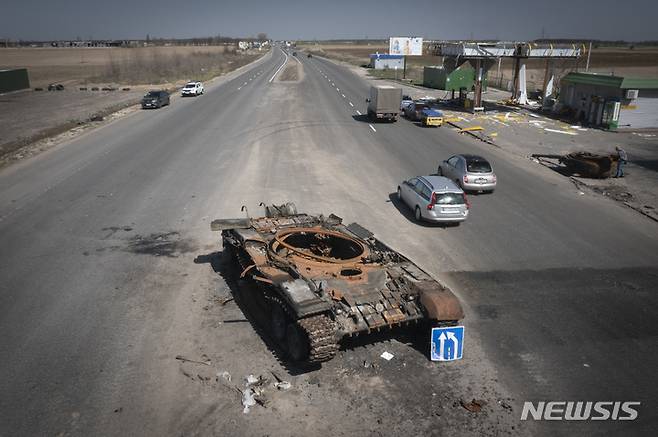 [키이우(우크라이나)=AP/뉴시스]지난15일 우크라이나 키이우로 가는 도로 모습. 최근 전투에서 파괴된 러시아 탱크가 도로 한가운데 서 있다. 2022.04.16.photo@newsis.com