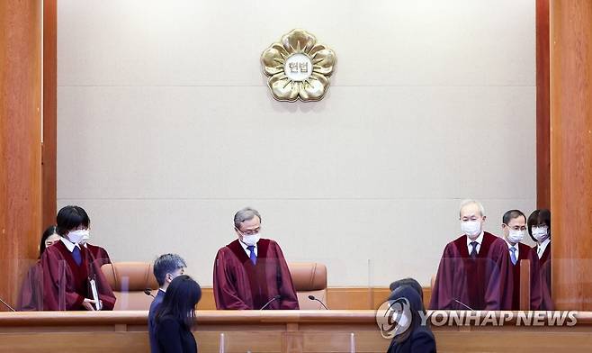 2021년 11월 25일 유남석 헌재 소장(가운데)을 비롯한 재판관들이 25일 오후 서울 종로구 헌법재판소 심판정에 들어서는 모습.  이날 헌재는 일명 윤창호법으로 불리는 도로교통법 148조의2의 규정 중 '음주운전 금지규정을 2회 이상 위반한 사람' 부분이 죄형법정주의의 명확성 원칙과 과잉금지원칙 등을 위배했다는 내용의 헌법소원에서 재판관 7대2의 의견으로 위헌 결정을 내렸다.  해당 조항은 음주운전 금지 규정을 2회 이상 위반한 사람을 2∼5년의 징역형이나 1천만∼2천만원의 벌금형에 처하도록 한다. 다수 의견 재판관들은 이 조항이 '책임과 형벌 간의 비례원칙'을 위반했다고 봤다. [연합뉴스 자료사진]