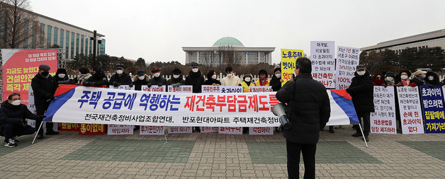 (서울=뉴스1) 김진환 기자 = 전국재건축정비사업조합연대·반포현대아파트 주택재건축정비사업조합 관계자들이 21일 서울 영등포구 국회 앞에서 열린 재건축 초과이익 환수법안 개정 촉구 집회에서 구호를 외치고 있다. 2022.2.21/뉴스1