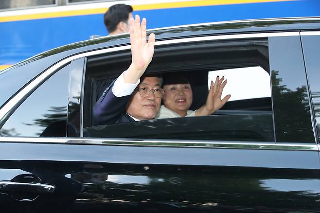 문재인 대통령과 김정숙 여사가 9일 오후 청와대 앞 분수대를 지나며 퇴근길 마중 나온 시민들에게 손을 들어 인사하고 있다. [연합]