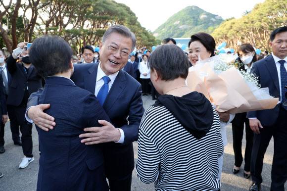 아쉬움을 뒤로 하고 - 문재인 대통령이 9일 오후 청와대를 나와 분수대 앞으로 향하던 중 꽃다발을 건네준 시민과 포옹하고 있다. 2022.5.9 연합뉴스