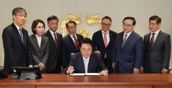 윤석열 대통령이 10일 서울 용산에 새로 마련된 대통령 집무실에서 1호 법안에 서명하고 있다. 뒷줄 왼쪽부터 김대기 비서실장, 강인선 대변인, 최상목 경제수석, 최영범 홍보수석, 안상훈 사회수석, 김성한 국가안보실장, 김용현 대통령경호처장 (사진=연합뉴스)