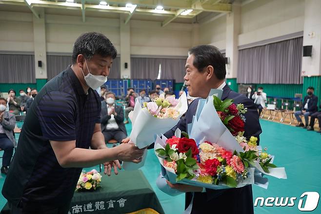 지난 9일 진만근 전남수영연맹 전무이사가 이임하는 김재무 전남체육회장에게 꽃다발을 전달하고 있다.(김재무 캠프 제공)2022.5.10/© 뉴스1