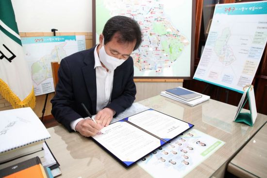 박겸수 강북구청장이 업무협약서에 서명하고 있다.