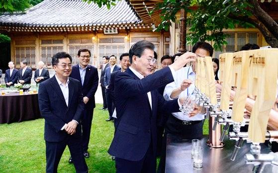 2017년 7월 청와대 상춘재앞에서 열린 기업인 간담회에서 문재인 전 대통령이 수제 맥주를 직접 따르고 있다. [당시 청와대사진기자단]