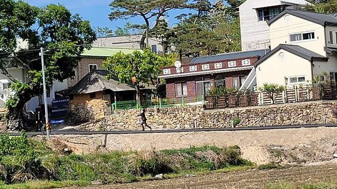 지난 10일 문재인 전 대통령 양산 사저 앞에서 퇴글길에 서류 가방을 던지는 탁현민 전 청와대 의전비서관의 모습. (클리앙 홈페이지 갈무리)© 뉴스1