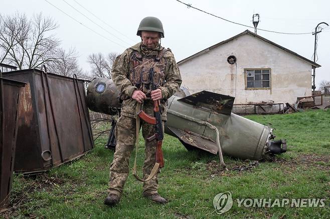 표적에 빗나간 러시아 미사일 주변을 살펴보는 우크라이나군 [로이터 연합뉴스 자료사진.재판매 및 DB 금지]