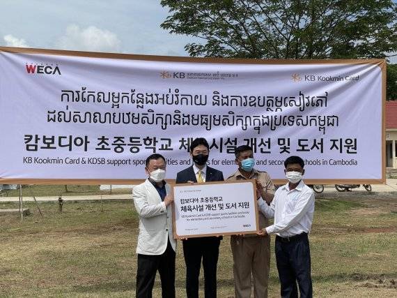 12일 캄보디아 칸달주 코레아루 초중등학교에서 열린 '캄보디아 초중등학교 체육시설 개선 및 도서지원' 기부금 전달식에서 이창권 KB국민카드 사장(왼쪽 두번째)이 행사에 참석한 관계자들과 기념촬영을 하고 있다. KB국민카드 제공