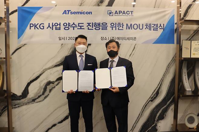 김형준 에이티세미콘 대표(왼쪽)와 이성동 에이팩트 대표(오른쪽)가 PKG 사업 양수도 진행을 위한 업무협약(MOU)을 체결하고 있다.