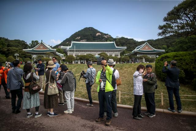 13일 오전 서울 종로구 청와대에서 열린 개방행사를 찾은 시민들이 본관을 배경으로 사진을 찍고 있다. 뉴시스