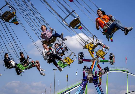 우크라이나 난민 어린이들이 지난달 독일 프랑크푸르트에서 축제에 초청 받아 도움을 주는 어른들과 함께 놀이기구를 즐기는 모습. 독일은 메르켈 총리 시절 100만 명 넘는 대규모 난민을 받아들였고, 국제 사회에서 새로운 ‘도덕적 리더’로 자리매김했다. [AP=연합뉴스]