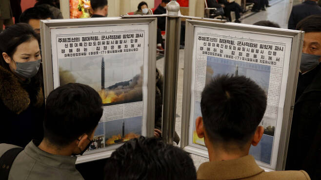 북한 시민들이 지난 3월 25일 평양 지하철 전승역에서 대륙간탄도미사일 발사 소식이 실린 노동신문을 보고 있다. / AP연합뉴스
