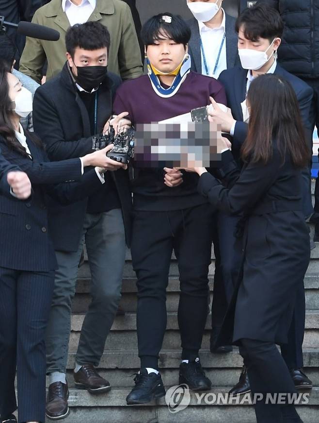 미성년자를 포함한 여성들의 성 착취물을 제작·유포한 혐의를 받는 ‘박사방’ 운영자 조주빈이 2020년 3월 25일 검찰로 송치되기 위해 서울 종로경찰서를 나서고 있다. 이날 기자들 앞에 선 조씨는 ’멈출 수 없었던 악마의 삶을 멈춰 주셔서 감사합니다“고 심경을 밝혔다. [연합]