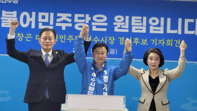 더불어민주당 여수시장 경선에 참여했던 전창곤, 김유화 예비후보가 정기명 후보와 함께 손을 들고 원팀을 선언하고 있다. 정기명 캠프 제공