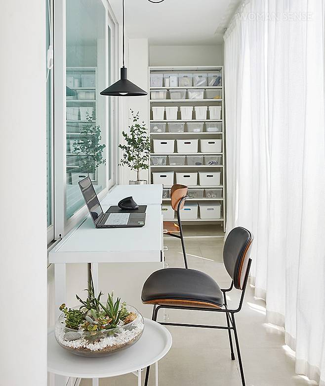 안방 앞 베란다는 확장하지 않고 그냥 뒀다. 잡동사니와 문구류, 공구 등을 수납하는 동시에 간이 테이블을 두어 볕 좋은 날 음악을 들으며 원고 작업 등을 하는 공간으로 활용한다. 의자는 큰바다가구점 위드 체어·원스플레이스 바이오 사이드 체어, 수납 박스는 공간치유 위드, 핸들 스토커는 공동 구매로 구입했다.