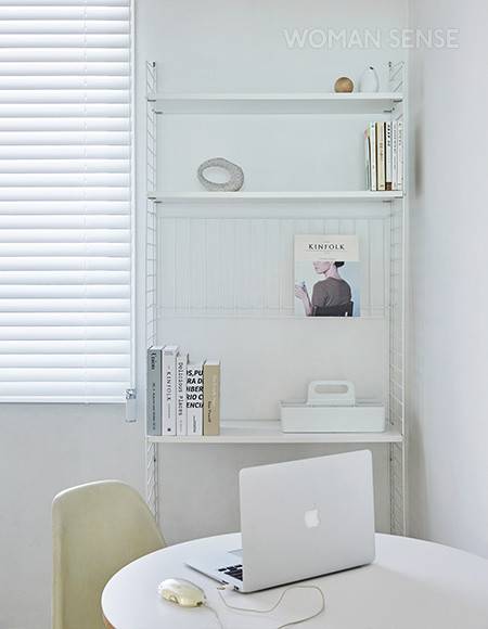 안방 옆 작은방 역시 공간을 나눠 부부의 서재로 꾸몄다. 스트링 시스템 선반에는 지금 읽거나 필요로 하는 최소한의 책만 놓아 깔끔함을 유지한다. 의자는 허먼밀러 임스 체어, 벽 조명은 르코르뷔지에가 세운 조명 회사 네모라이팅의 랑프 드 마르세유.