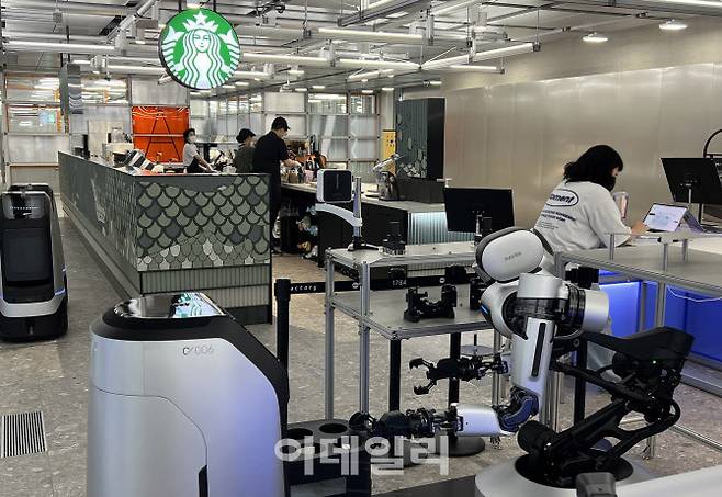 네이버 1784 사옥에 입점한 스타벅스 내에서 커피 배달을 맡은 네이버랩스의 루키 로봇을 양팔 로봇이 소독 중이다. (사진=이대호 기자)