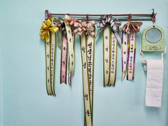 교무실  벽에 걸려있는 리본들엔 스승의 은혜에 감사한다는 글씨가 적혀있다. 10년도 넘은 것들이다.