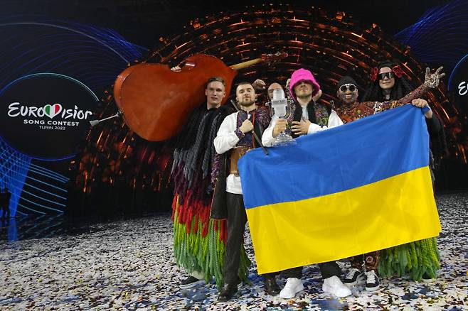 이탈리아 북서부 토리노에서 14일(현지시간) 유럽 최대 팝 음악 축제 ‘유로비전 2022’에 출전한 우크라이나 6인조 남성 밴드 ‘칼루시 오케스트라’가 우승한 뒤 국기를 펼쳐 들고 기뻐하고 있다.AP연합뉴스