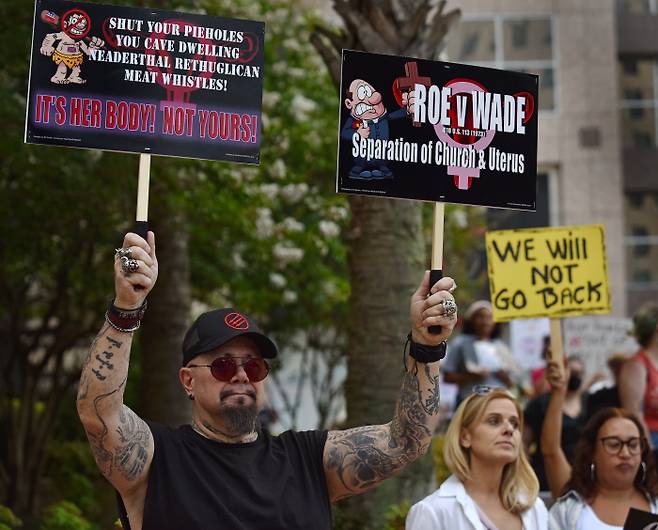 14일(현지시간) 미국 플로리다 주 올랜도에서 열린 임신중단 권리 폐지 반대 집회에서 한 남성 참가자가 “그녀의 몸은 당신의 것이 아니다”라고 적힌 피켓을 들고 있다. UPI연합뉴스.