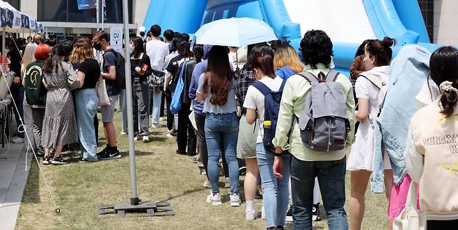 지난 11일 오후 서울 종로구 성균관대 금잔디광장에서 열린 대동제 축제에서 학생들이 다양한 굿즈를 받기 위해 줄을 서고 있다. [연합]