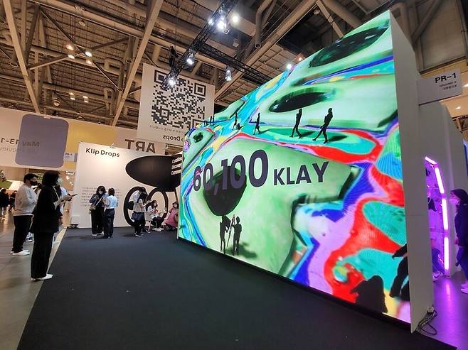 ‘아트부산 2022’의 ‘엔에프티 아트랩’ 전시 현장. 대형 화면에 투사되는 엔에프티 동영상 이미지를 관객들이 감상하고 있다. 노형석 기자