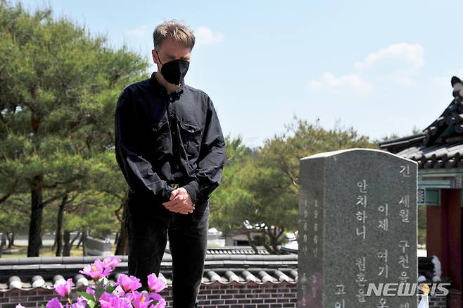 [광주=뉴시스] 이영주 기자 = 5·18민주화운동 42주기를 이틀 앞둔 16일 오후 광주 북구 운정동 5·18 민주묘지에서 독일에서 온 아스콜트 히쯜러(55)씨가 행방불명된지 42년 만에 유해를 찾은 고 김광복 군의 가묘를 향해 추모하고 있다. 2022.05.16 leeyj2578@newsis.com