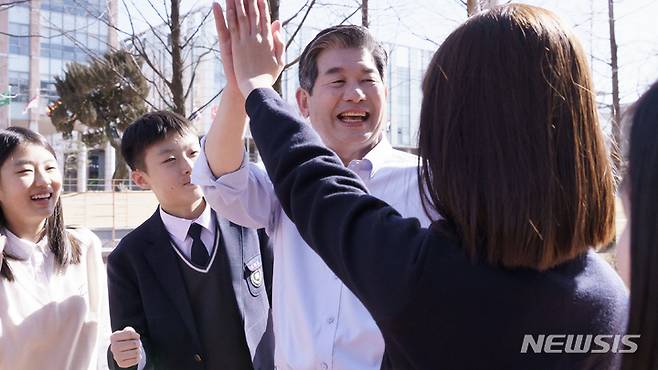 [인천=뉴시스] 이루비 기자 = 최계운 인천시교육감 후보가 학생과 하이파이브를 하고 있다. (사진=최계운 캠프 제공)