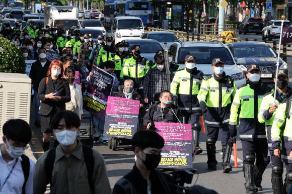 장애인 권리 예산 보장 촉구 행진 - 전국장애인차별철폐연대(전장연) 소속 장애인들이 16일 오전 장애인 권리 예산 보장을 요구하며 서울 신용산역에서 삼각지역 방향으로 행진하고 있다.  2022.5.16 연합뉴스