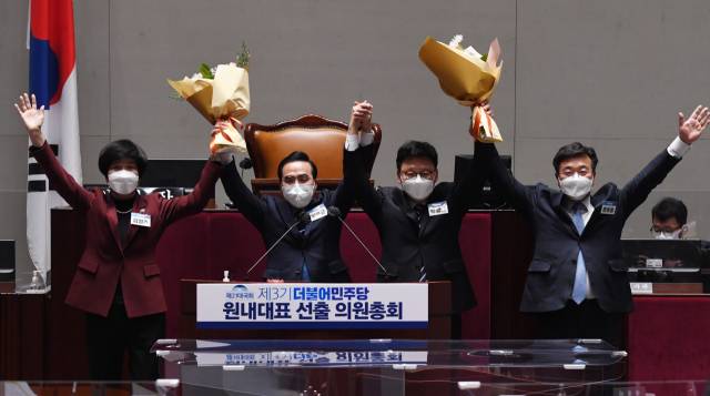 박홍근 더불어민주당 신임 원내대표가 지난달 24일 국회에서 열린 의원총회에서 새로운 원내대표 선출된 뒤 꽃다발을 들어 올리고 있다. 오른쪽부터 윤호중 공동비상대책위원장, 박광온 의원, 박홍근 신임 원내대표, 김영주 선관위원장. /연합뉴스