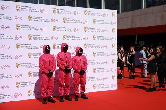 지난 5월 8일 영국 런던에서 열린 영국 아카데미 시상식에서 '오징어 게임' 캐릭터 복장을 한 참석자가 레드카펫에서 포즈를 취했다. [로이터=연합]