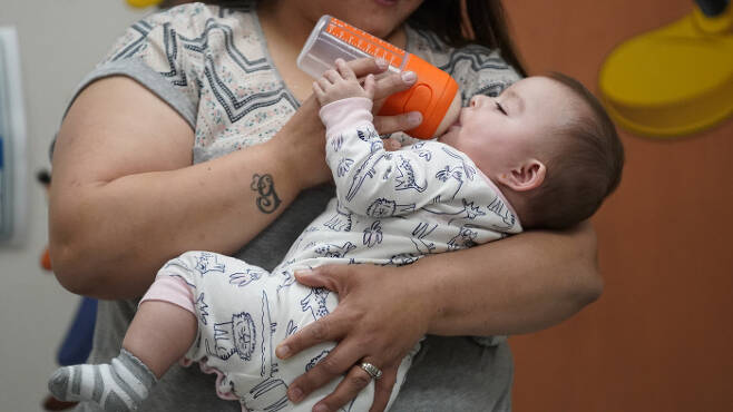 미국 유타의 한 여성이 9개월 된 딸에게 우유를 먹이고 있다. 조 바이든 대통령은 12일(현지시간) 전국적인 유아용  분유 부족 사태에 대한 행정부의 대응을 강화했다. AP연합뉴스