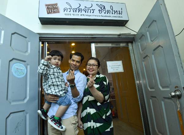 15일 경기도 안산 새생명태국인교회 앞에서 남편 윳씨와 아내 무이씨, 그의 아들 태윤군이 손 하트를 만들며 활짝 웃고 있다. 안산=신석현