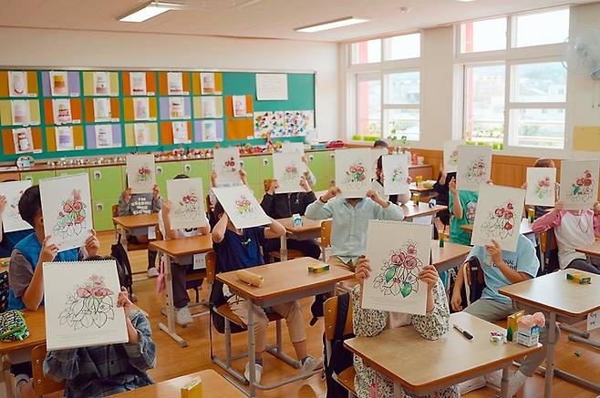 [제주=뉴시스] 이니스프리모음재단의 ‘주니어 이니클래스’에 참여한 제주시 도평초등학교 학생들이 지난 16일 색칠한 컬러링북을 들어보이고 있다. (사진=이니스프리모음재단 제공) 2022.05.17. photo@newsis.com *재판매 및 DB 금지