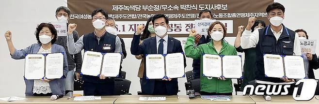 제8회 전국동시지방선거 제주도지사 선거에 출마한 녹색당 부순정 후보(오른쪽에서 두 번째)와 무소속 박찬식 후보(오른쪽에서 세 번째)가 18일 오전 전국민주노동조합총연맹 제주지역본부 사무실에서 '제주를 지키는 12대 정책' 정책협약 체결 후 기념촬영을 하고 있다.2022.5.18/뉴스1© 뉴스1