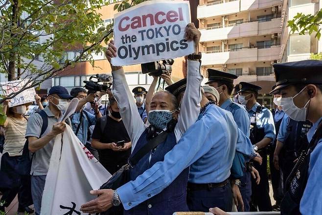 도쿄올림픽 반대 시위대가 지난해 7월 일본 도쿄에 있는 토마스 바흐 위원장 투숙 호텔로 진입하려 하자 일본 경찰이 이를 막아서고 있다. 도쿄/AFP 연합뉴스