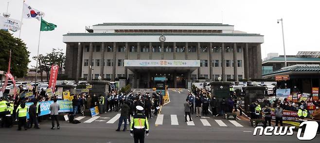 제주 제2공항 건설사업에 대한 도민들의 여론로 갈리고 있다. 지난해 3월 정세균 국무총리가 제주도청을 방문한 가운데 제주 제2공항 찬성(사진 왼쪽)과 반대 단체가 도청 정문 앞에서 비슷한 시간 기자회견을 열고 있다.2021.3.19/뉴스1 © News1 고동명 기자