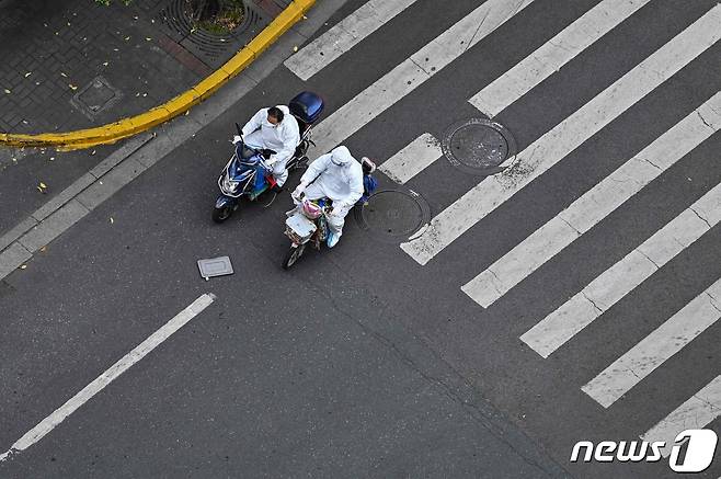 코로나 봉쇄령이 내려진 중국 상하이의 텅 빈 거리에서 배달원이 스쿠터를 타고 있다. © AFP=뉴스1 © News1 우동명 기자